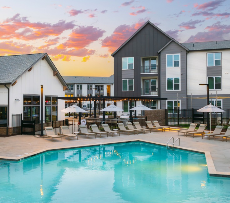 Pool courtyard at sunset with lounge seating and umbrellas Pool courtyard at sunset with lounge seating and umbrellas