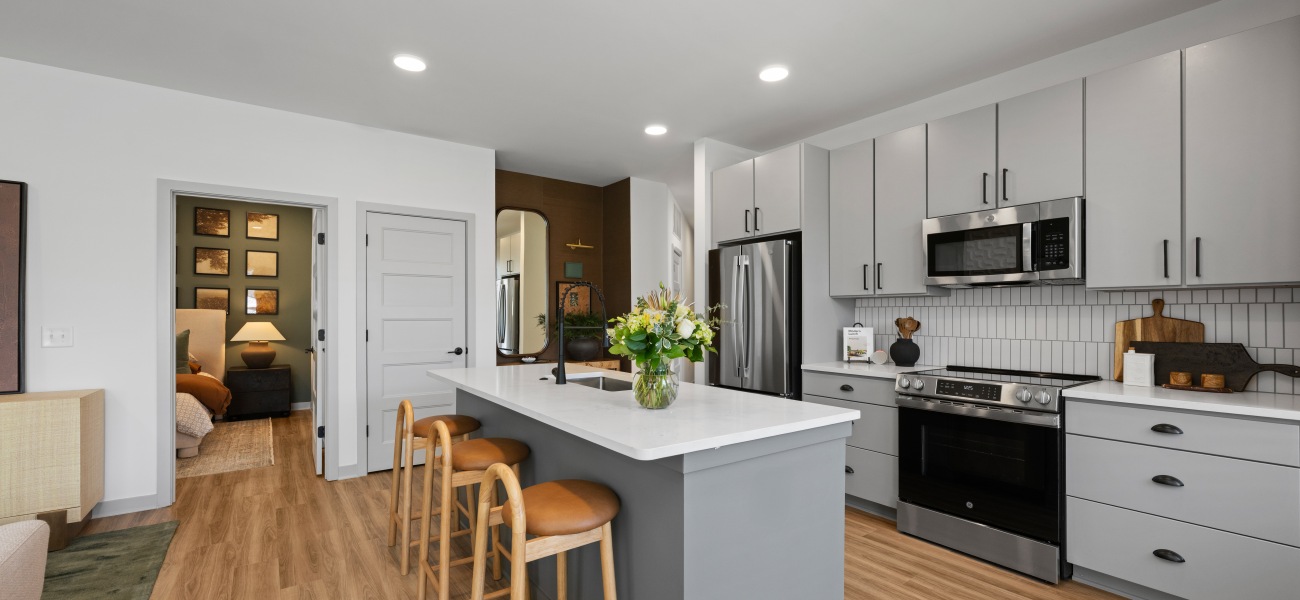 living area kitchen island barstools fridge stove cabinets wood floors living area kitchen island barstools fridge stove cabinets wood floors